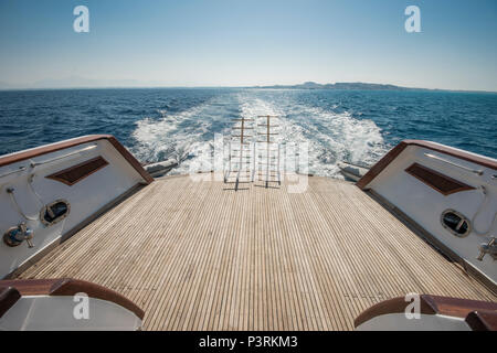 Metall Stahl Leitern auf der Rückseite Teak Deck eines großen Luxury Motor Yacht segeln auf einer tropischen Ozean Stockfoto