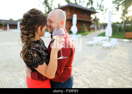 Mann tanzen mit Frau hält Glas Wein auf Hinterhof. Stockfoto