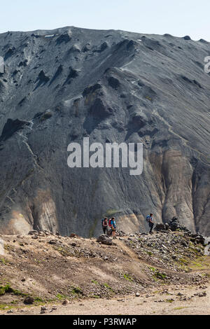 Wanderer auf dem Laugavegur Trail mit dem vulkanischen Berg der Blahnukur als Kulisse, Landmannalaugar, Island. Stockfoto