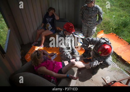 Us-Soldaten und Piloten zur Massachusetts National Guard zugewiesen, der Behandlung eines Patienten während der Wachsam Guard 2016 im Camp Ethan Allen Training Website, Jericho, Vt, 31. Juli 2016. Wachsam Guard ist eine National Emergency Response Übung, durch die Nationalgarde und NORTHCOM, die National Guard Einheiten bietet eine Gelegenheit, die Zusammenarbeit und die Beziehungen zu regionalen zivilen, militärischen zu verbessern, und der Partner in der Vorbereitung für Notfälle und Katastrophen gefördert. (U.S. Air National Guard Foto von Airman 1st Class Jeffrey Tatro) Stockfoto