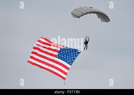 Ein US Air Force pararescueman steigt mit der amerikanischen Flagge bei der Eröffnungsfeier für Arctic Thunder Open House bei Joint Base Elmendorf-Richardson, Alaska, am 31. Juli 2016. Die alle zwei Jahre stattfindende Veranstaltung ist historisch die größte Mehrtägige Veranstaltung in Staat und einer der führenden Antenne Demonstrationen in der ganzen Welt. Arctic Thunder mit mehr als 40 wichtigen Interpreten und Masse wirkt, 30. Juli und 31. (U.S. Air Force Foto/Alejandro Pena) Stockfoto