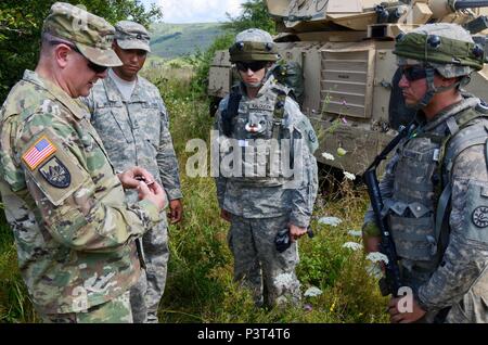 Direktor der Army National Guard, Generalleutnant Timothy Kadavy, erklärt die Symbolik seiner Münze, bevor Sie die Präsentation vor Soldaten aus 2.BATAILLON, 116 Cavalry Brigade Combat Team während der Übung Sabre Guardian 2016, 31. Juli an der Rumänischen Landstreitkräfte Combat Training Center in Cincu, Rumänien. Sabre Guardian ist eine multinationale militärische Übung mit rund 2.800 Soldaten aus zehn Nationen, darunter Armenien, Aserbaidschan, Bulgarien, Kanada, Georgien, die Republik Moldau, Polen, Rumänien, der Ukraine und den USA die Ziele dieser Übung handelt es sich um multinationale Unternehmen, die regionalen und joi zu bauen Stockfoto