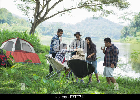 Freunde Entspannende außerhalb der Zelte auf dem Campingplatz Stockfoto