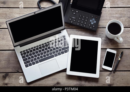 Laptop mit weißen digitalen Tablette öffnen und Smartphone auf dem Schreibtisch von oben mit isolierten Bildschirm Stockfoto