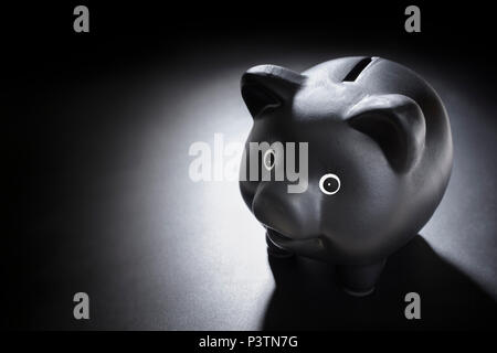 Schwarz Sparschwein auf blackboard Hintergrund Stockfoto