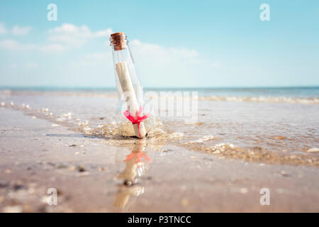 Eine Flaschenpost angespült auf einem Strand Konzept für Hilfe, sos, Notfall und Hilfe Stockfoto