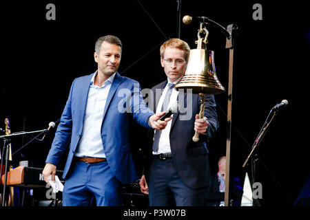 16 Juni 2018, Deutschland, Kiel: Daniel Günther (R) der Christlich Demokratischen Union (CDU), Ministerpräsident von Schleswig-Holstein, Ringe die Kieler Woche (lit. Kieler Woche) Glocke an die traditionelle "GLASEN". Moderator Gerrit Derkowski steht auf der linken Seite. Bis Sonntag, erwarten die Veranstalter bis zu drei Millionen Besucher aus aller Welt im Norden Europas größte Sommerfest. Foto: Frank Molter/dpa Stockfoto