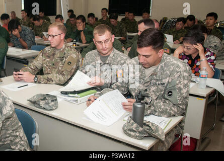 Von links nach rechts: Armee Oberstleutnant Bryan C. Jones, Commander, U.S. Army Aviation Battalion-Japan, Armee Maj. Nolan D. Roggenkamp (Mitte), Operations Officer, USAABJ Links, und Army Staff Sgt. Joel Redman, Crew Chief, USAABJ, überprüfen Sie die Agenda für die zweite tachikawa Hubschrauber Konferenz durchgeführt, 26. Juli 2016, im Camp Tachikawa, Japan. Durch die JGSDF Östlichen Armee wird die Konferenz trafen sich Vertreter von der japanischen Selbstverteidigungsstreitkräfte, United States Military Zweige, und Japans Zivilluftfahrtbehörden, um Informationen auszutauschen und Strategien zu Hubschrauber zu führen. Stockfoto