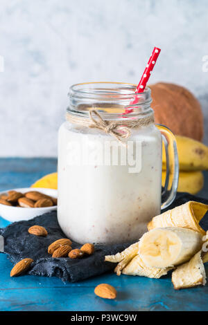 Schütteln oder Smoothie aus Mandelmilch, Banane und Kokosnuss in einem Maurer Tasse. Stockfoto