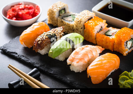 Sushi und Sushi Roll on Black Stone Tabelle einrichten. Traditionelle asiatische Lebensmittel. Close Up. Stockfoto