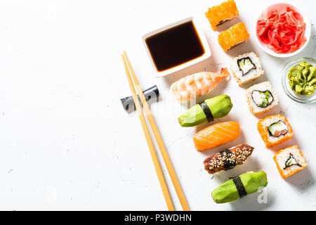 Sushi und Sushi Roll auf weißem Hintergrund. Traditionelle asiatische Lebensmittel. Ansicht von oben kopieren. Stockfoto