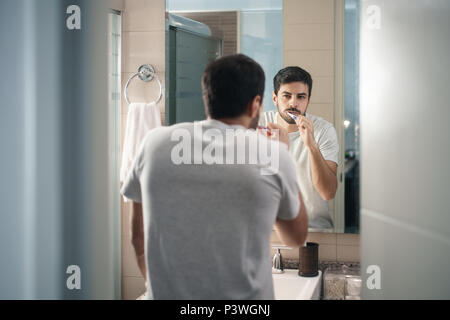 Hispanic Mann Zähneputzen in Bad am Morgen Stockfoto