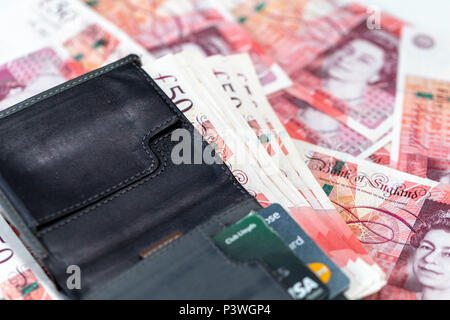 Eine Nahaufnahme eines Etui mit Kreditkarten und fünfzig Pfund Banknoten auf verstreut fünfzig Pfund Sterling Notizen Stockfoto