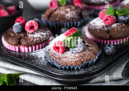 Schokolade orange Muffins oder Cupcakes mit frischen Beeren dekoriert. Gesunde hausgemachten Backwaren. Stockfoto