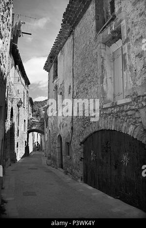 Einer ruhigen Gasse im mittelalterlichen Dorf Saint-Guilhem-le-Désert, Hérault, Royal, Frankreich. Schwarz und Weiss Stockfoto