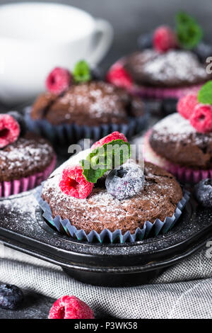 Schokolade orange Muffins oder Cupcakes mit frischen Beeren dekoriert. Gesunde hausgemachten Backwaren. Stockfoto