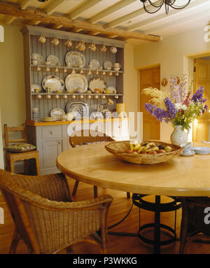 Korbstühle in hellem Holz Tisch im Esszimmer mit hellen Blau lackierte Kommode Stockfoto