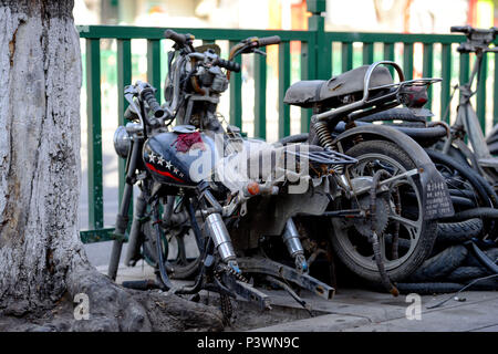 Peking, China - MÄRZ 10, 2016: Fahrräder, Roller und Autos in Peking Straßen. Der Straßenseite des verlassenen gebrochen Motorräder. Stockfoto