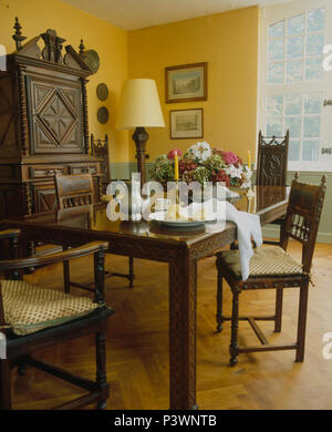 Parkettboden und Möbeln aus dunklem Holz in gelb French Country Esszimmer Stockfoto