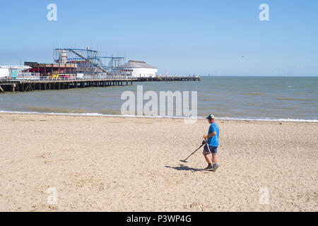 Metall detectorist entlang der High Water Mark suchen am Strand von Clacton-on-Sea. Stockfoto