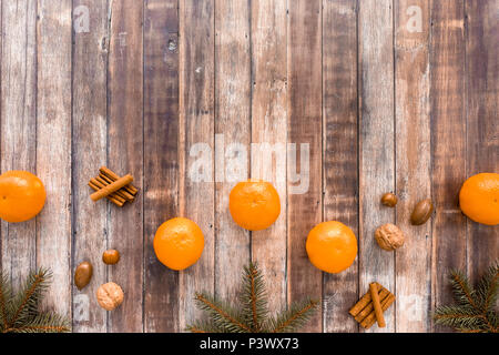 Weihnachten Grenze mit Clementinen, Zimtstangen, Tannenbaum, Zweige und die Muttern an der dunkelbraunen Hintergrund mit viel Platz kopieren. Stockfoto