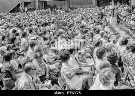 FORT SMITH, AR, USA - August 10, 1975 -- Eine grosse Masse der Bereich Bewohner und Vietnamesische Flüchtlinge hören als Präsident Gerald Ford neu begrüßt - kamen Flüchtlinge vor kurzem eingerichteten Flüchtlingslager am Fort Chaffee, AR. Stockfoto