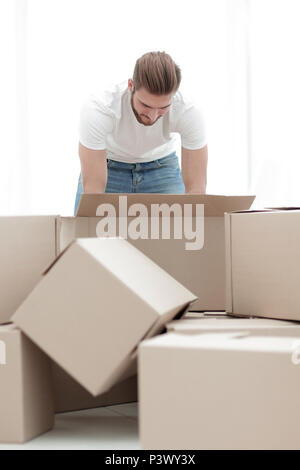 Männliche Sortierung Sachen in die neue Wohnung. Stockfoto