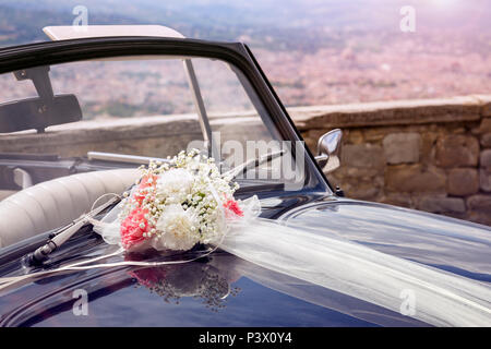 Vintage Hochzeit Auto mit Blumenstrauß und Band auf der Motorhaube Stockfoto