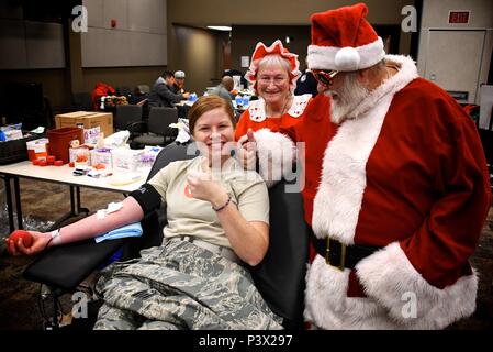 Mehrere Flügel militärische Flieger und Zivilisten unterschieden durch die Spende von Blut in der 932Nd Airlift Wing Hauptsitz am 04.12.14, 2017 in Scott Air Force Base, Illinois heraus hängen und Spenden mit Santa und Frau Claus ist Staff Sgt. Kaitlyn Kennedy, 932Nd Entwicklung und Ausbildung Flug Koordinator. Sie sagte: "Ich bin in meiner Oma. Sie pflegte, Blut zu spenden, bevor sie starb, 26 Gallonen über ihrer Lebenszeit, und ich bin auf dieses Vermächtnis." Kennedy hat über eine Gallone von Blut und mit jeder Spende gespendet, weiß sie, drei Leben durch das Amerikanische Rote gespeichert werden. Stockfoto