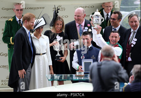 Prinz Harry, Herzog von Sussex (links) und Meghan, Herzogin von Sussex vorhanden die Auszeichnungen Jockey Frankie Dettori (mit Pokal, rechts) und Trainer John gosden (Mitte, hinten) nach ohne Bewährung des St James's Palace Stakes während der Tag des Royal Ascot Hotel in Ascot Pferderennbahn gewonnen. Stockfoto