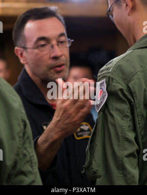 Mark Thompson, 428th Fighter Squadron F-15 SG Fluglehrer, patches Republik Singapur Air Force Maj. Wang Kee Yong, 428th Fighter Squadron F-15 SG-Pilot, während eines Patches Zeremonie zum 22. Juli 2016 in der Mountain Home Air Force Base, Idaho. Normalerweise beschränkt auf "Patches", Bordpersonal, die bereits ihre Ausbilder patches erworben haben, die Zeremonie markiert den Übergang vom Studium zum Lehrer. (U.S. Air Force Foto von älteren Flieger Lauren-Taylor Levin/Freigegeben) Stockfoto