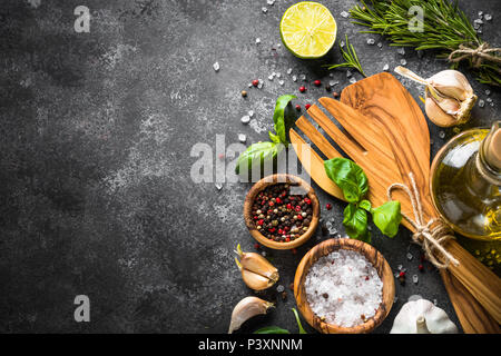 Olivenöl, Kräuter und Gewürze auf einem dunklen Stein Tabelle. Zutaten zum Kochen, Ansicht von Oben, Kopieren. Stockfoto