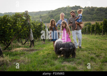 Glückliche Familie genießt Spaziergang im Weinberg Stockfoto