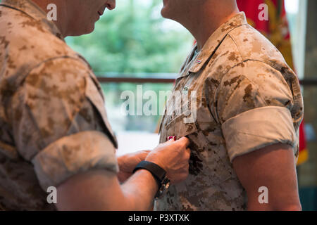 Us Marine Corps Brig. Gen. Christopher Mahoney, Direktor für Strategie und Pläne Division, Stifte von einem Meritorious Service Medal auf Chief Warrant Officer 5 Bradley's Goode Tasche während der Goode Ruhestand Zeremonie an der Semper Fidelis Kapelle, Dreieck, Virginia, 7. Oktober 2016. Goode zog sich nach 26 Jahren des Herrn Abgeordneten und treuen Dienst. (U.S. Marine Corps Foto von Cpl Timothy A. Turner) Stockfoto