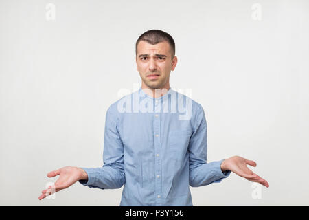 Kaukasische Mann im blauen Hemd wirft ihm seine Hände. Er ist mit den Ergebnissen verwechselt. Stockfoto