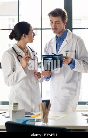 Zwei junge engagierte Ärzte gemeinsam analysieren eine Röntgenaufnahme von Stockfoto