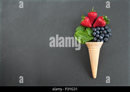 Frische, natürliche Aromen aus ein Eis Kegel einschließlich Erdbeere, Minze und Blaubeeren Stockfoto