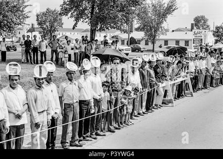 FORT SMITH, AR, USA - 10. August 1975 - langen Linien der vietnamesischen Flüchtlinge willkommen Präsident Gerald Ford an die neu eröffnete vietnamesischer Flüchtling Zentrum am Fort Chaffee, AR. Die Männer, die in diesem Teil der Zeile haben Hüte, die Zauber 'Willkommen Präsident Gerald Ford." Stockfoto