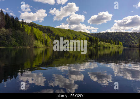 Landschaft - Fluss mit schönen bewaldeten Ufer und Himmel mit Wolken im Wasser widerspiegelt Stockfoto