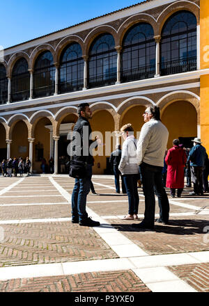 Touristen in einem kleinen gepflasterten Hof, Reales Alcázares de Sevilla, Sevilla, Andalusien, Spanien. Stockfoto