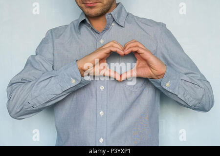 Eine Erklärung der Liebe. Valentinstag. Glücklich schöner Mann Herz mit den Fingern. Ein junger Mann in der Liebe zeigt seine Gefühle Stockfoto