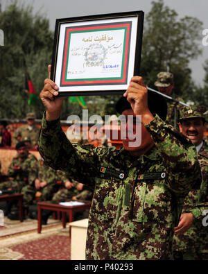 Nationale afghanische Armee Private Mohammed Khaili, der 100.000 BWC-Absolvent durch Alphabetisierung zu gehen, ist eine Plakette und Stift in Kabul Militärische Ausbildungszentrum in Kabul, Afghanistan, Juli 28, 2011 ausgezeichnet, in Anerkennung der Leistungen der afghanischen nationalen Sicherheitskräfte im Bereich der Bildung und Alphabetisierung. Basic Krieger Training Kandak 162 graduierte 1.287 Soldaten, von denen alle militärischen und Alphabetisierung an verschiedenen afghanischen nationalen Armee Zweig Schulen oder den konsolidierten Fielding Panoramaeinstellungen in Kabul weiter. Stockfoto