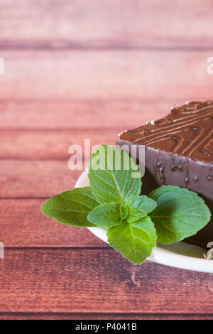 Stück der Köstlichen souffle Kuchen in der Schokolade auf einem dunklen Hintergrund mit einem Zweig Minze. Stockfoto