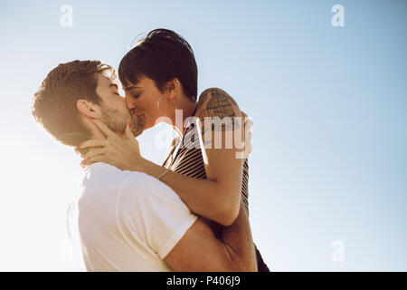 Schönes Paar Küssen im Freien. Liebevolle Frau, die ihren Freund zu küssen. Stockfoto