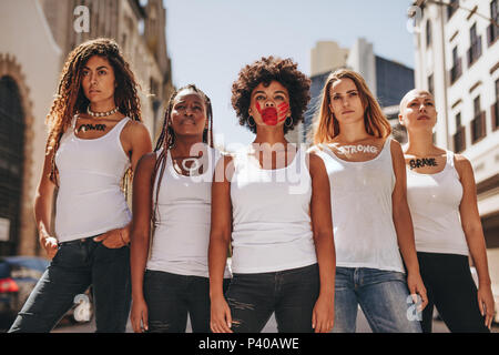 Gruppe von Frauen Demonstranten März auf der Straße für die Rolle der Frauen. Aktivistinnen in dress code demonstrieren im Freien. Stockfoto