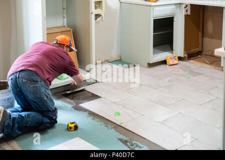 Ein 40 Jahre alter Kaukasischer Mann verlegen Fliesen in einem Hause Umbau in Wichita, Kansas, USA. Stockfoto