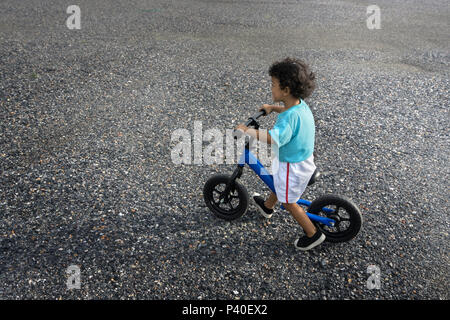 Asiatische Kind am ersten Tag spielen balance Bike. Kleinen Jungen lernen mit Fahrrad zu fahren. Stockfoto