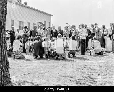 FORT SMITH, AR, USA - 10. August 1975 - Als Teil der einladenden Zeremonien für das Fort Chaffee vietnamesischer Flüchtling Center, einer Gruppe von vietnamesischen Kindern Musik für Präsident Gerald Ford. Der Präsident wird von John Paul Hammerschmidt (R., AR) zu seiner Rechten und Arkansas Gouverneur David Pryor (Dem.) an der linken Seite des Präsidenten flankiert. Stockfoto