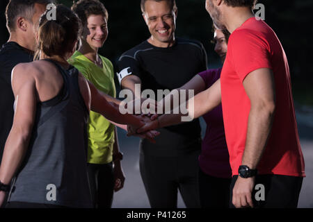 Gruppe von gesunden Läufer, fünf auf einander beim Erfolg feiern nach dem Training. Stockfoto