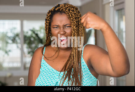 Afrikanische amerikanische Frau zu Hause verärgert und wütend die Faust frustriert und wütend, während Schreien vor Wut. Wut und aggressives Konzept. Stockfoto